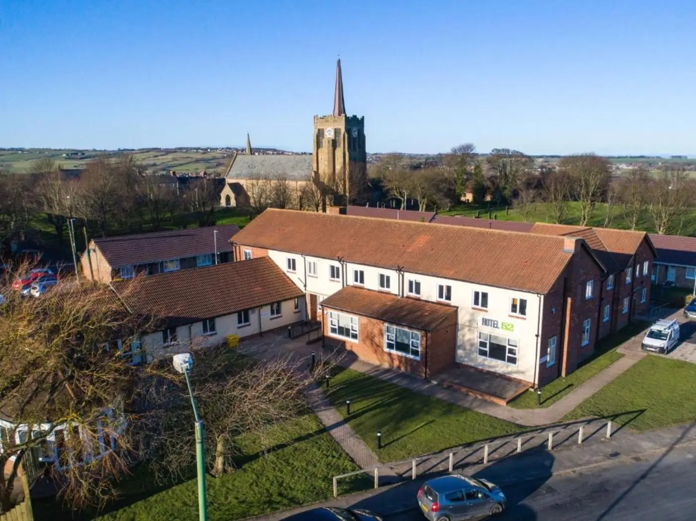 Hotel 52 Stanley exterior with historic church behind, Stanley, County Durham